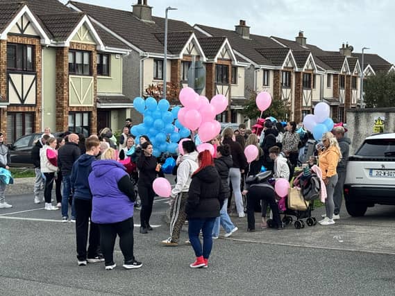 People gather ahead of a balloon release ceremony in Birchwood on Wednesday