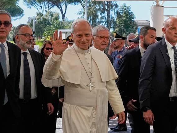 Pope Leo waves as he arrives at hospital