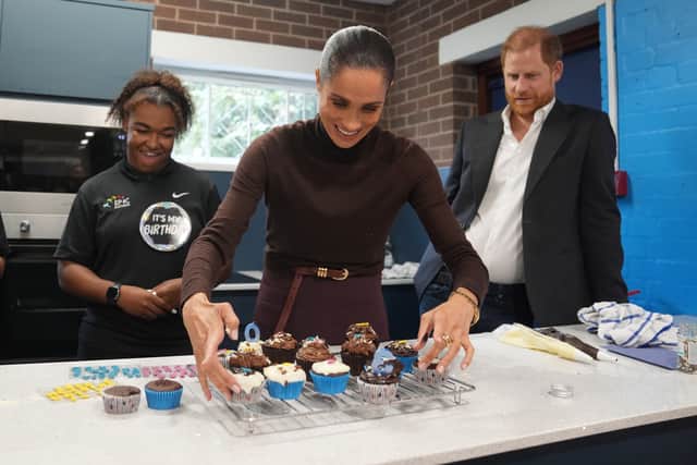 The Duke of Sussex watches as the Duchess of Sussex arranges birthday cupcakes (Joe Giddens/PA)