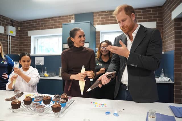 Harry licks icing from his hand during the visit to Epic Partners (Joe Giddens/PA)