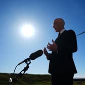 John Swinney standing in front of a wind turbine