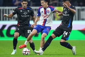 Lyon’s Keito Nakamura is challenged by Crystal Palace’s Anan Khalaili, left, and Dario Osorio during the Europa League opening phase soccer match between Lyon and Crystal Palace in Lyon, France,