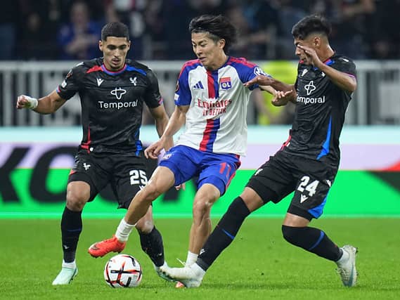 Lyon’s Keito Nakamura is challenged by Crystal Palace’s Anan Khalaili, left, and Dario Osorio during the Europa League opening phase soccer match between Lyon and Crystal Palace in Lyon, France,