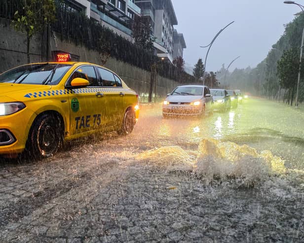 Vehicles drive along a partially flooded road during heavy rain in Istanbul