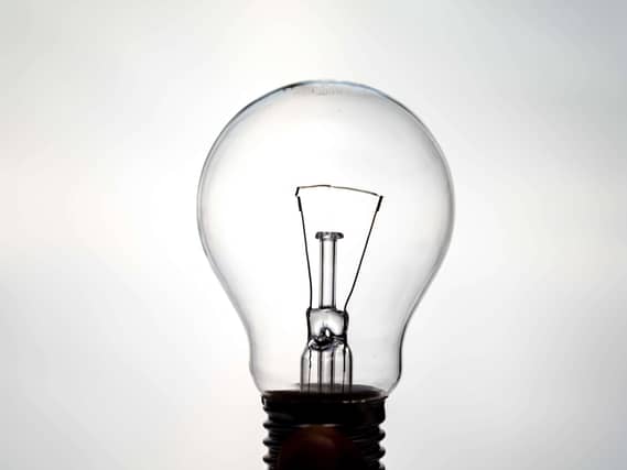 Incandescent light bulb, photographed against the light, which appears to be on. Electricity and renewable energy sources.