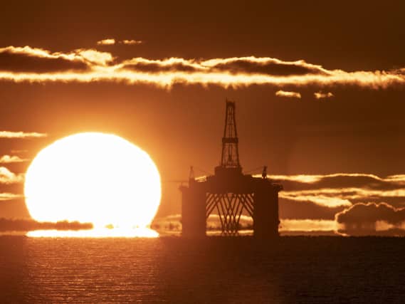 The sun rising behind an oil platform