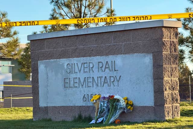 Flowers beside a sign at Silver Rail Elementary School (Haven Daley/AP)