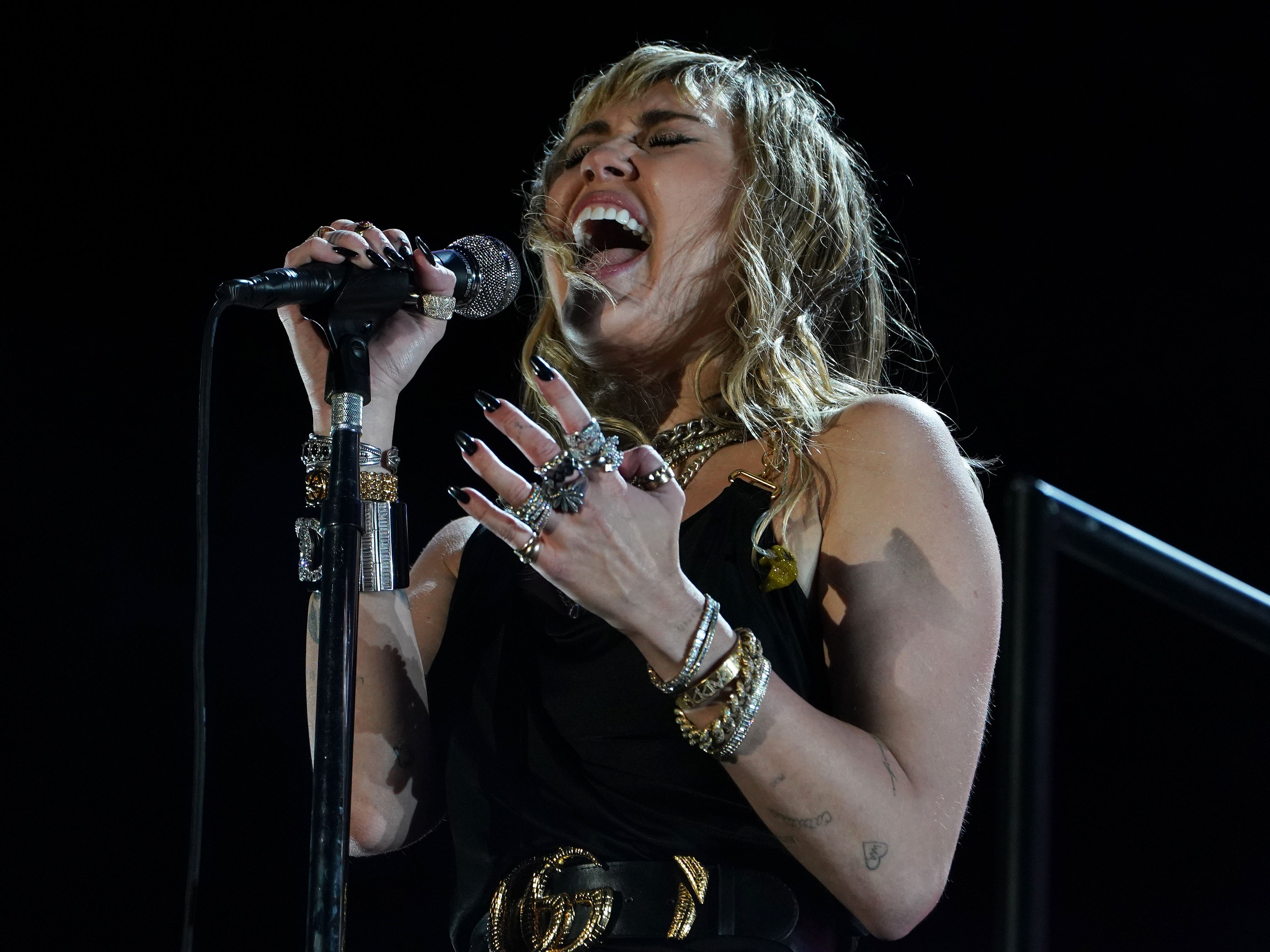 Miley Cyrus singing into a microphone