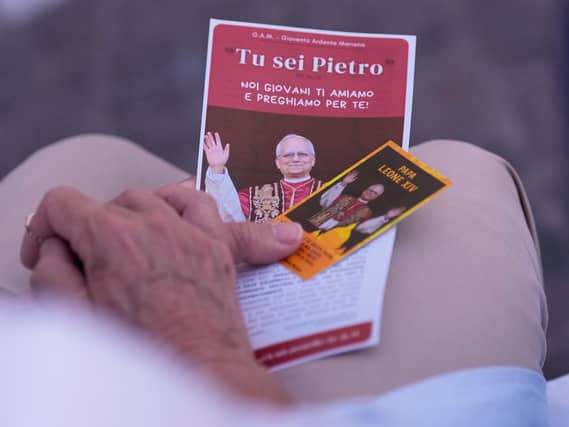 A woman holds a picture of the Pope