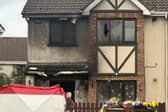 Floral tributes outside the scene of the arson attack at a house in Birchwood, Waterford
