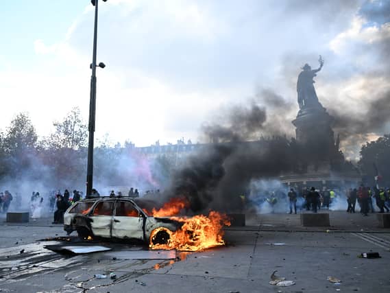 A car burns at Place de La Republique during a protest against rising living costs in Paris