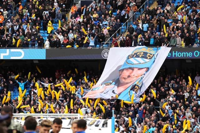 Manchester City fans with a tifo and inflatable bananas in the stands (Martin Rickett/PA)