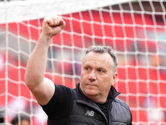 Oldham manager Micky Mellon punches his fist in the air