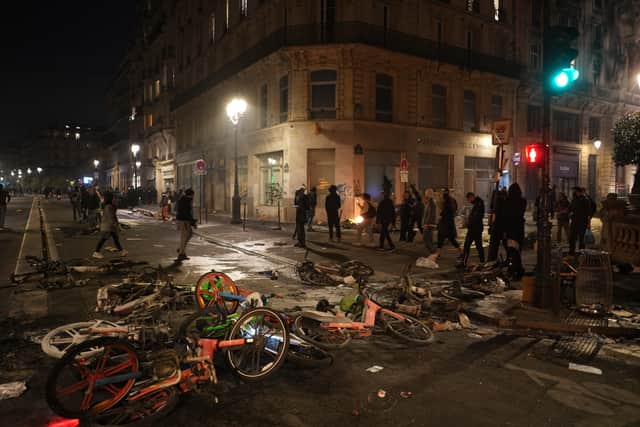 People walk past bicycles lying in the street after a demonstration against rising living costs in Paris (Thibault Camus/AP)