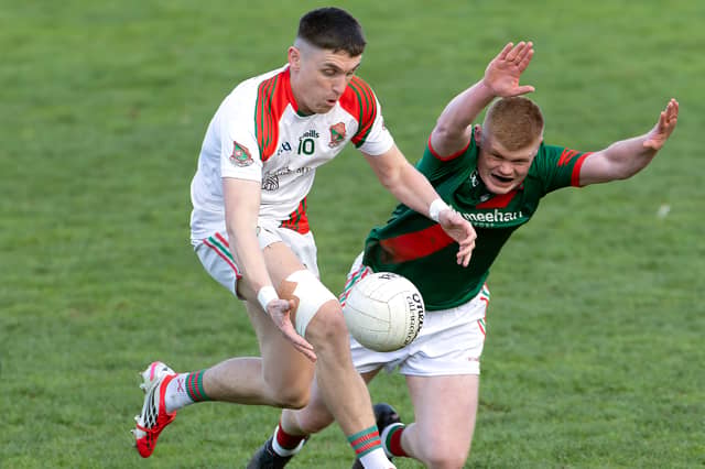 Suncroft forward Eoghan Lawless solo's his way through the attempted block down from Kevin Byrne of Milltown