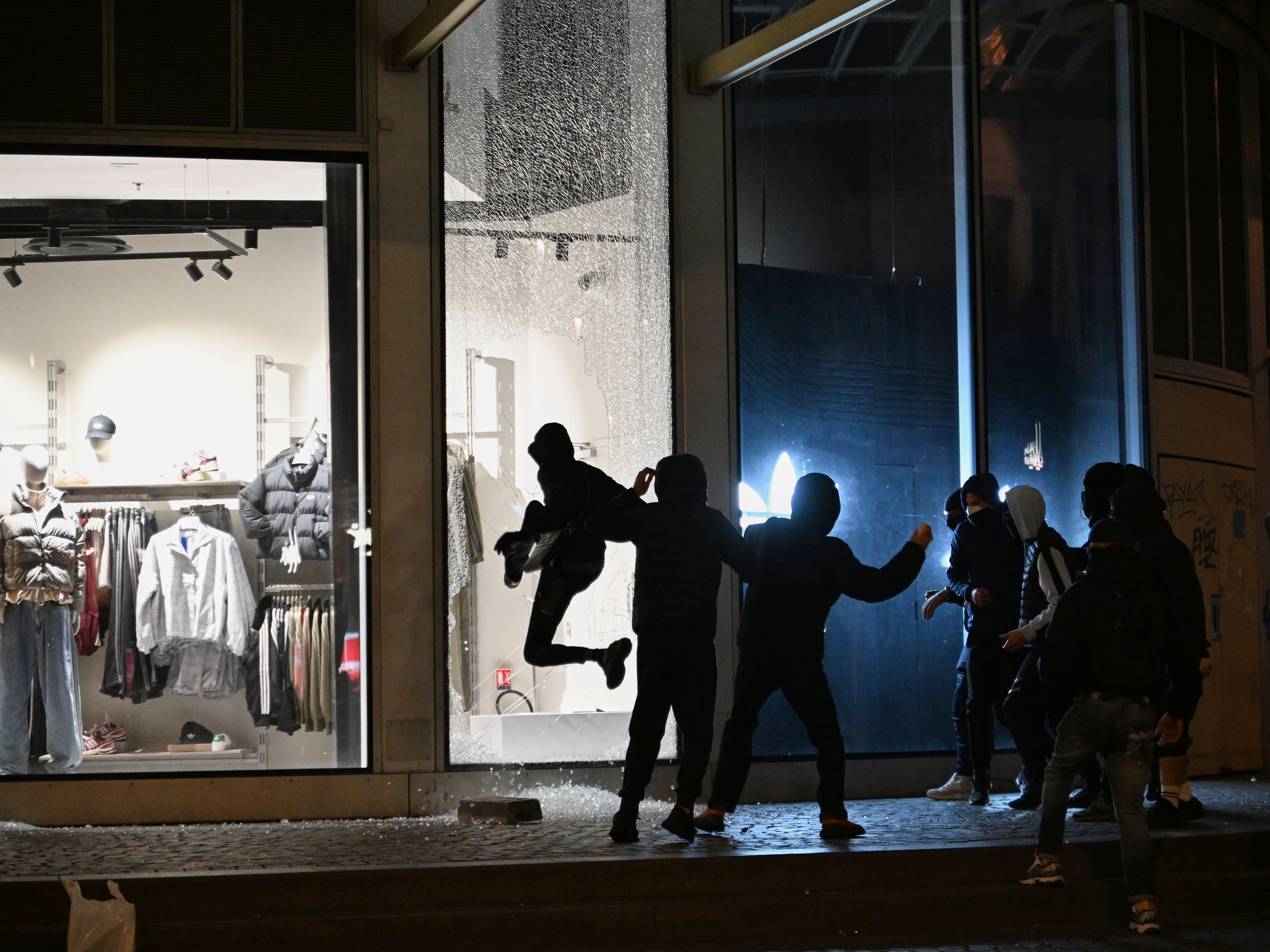 Youths break a store window