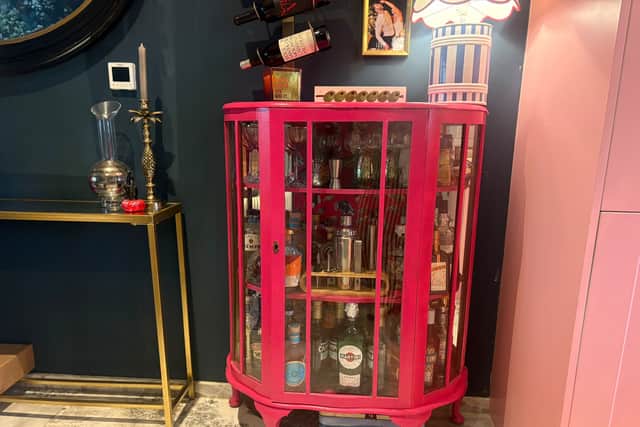 Collected for free on Facebook Marketplace, Lia Gold swapped out the glass shelves and made solid wood ones; covered the back in House of Hackney fabric, and repainted the unit to make a home bar cabinet (Lia Gold Interiors/PA)