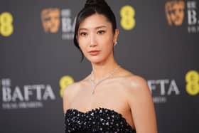 Ejae posing for photos at the Baftas in a black gown