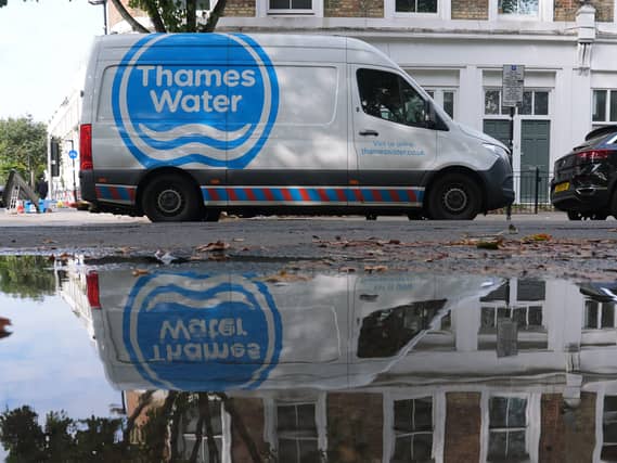 Thames Water van parked on a street, opposite a large puddle of water
