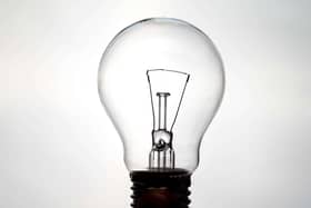 Incandescent light bulb, photographed against the light, which appears to be on. Electricity and renewable energy sources.