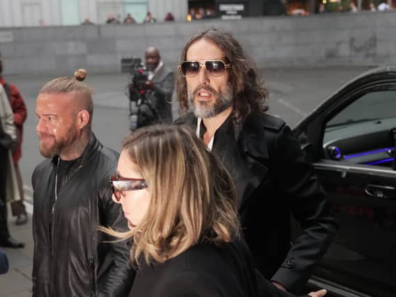 Russell Brand (centre) arrives with his wife Laura Gallacher at Southwark Crown Court