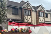 External view of a house showing signs of fire damage, with a forensic tent erected outside