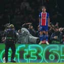 Vitinha stands on an advertising hoarding to celebrate after scoring in Paris St Germain's win over Barcelona