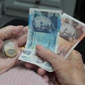 A woman holding coins and banknotes