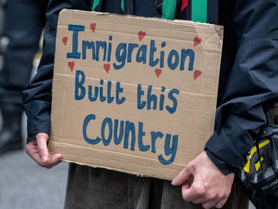 Close up of a sign that reads 'immigration built this country'