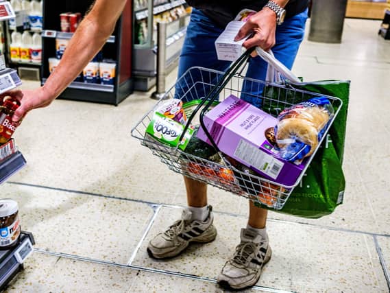 A shopper holding a basket in a supermarket