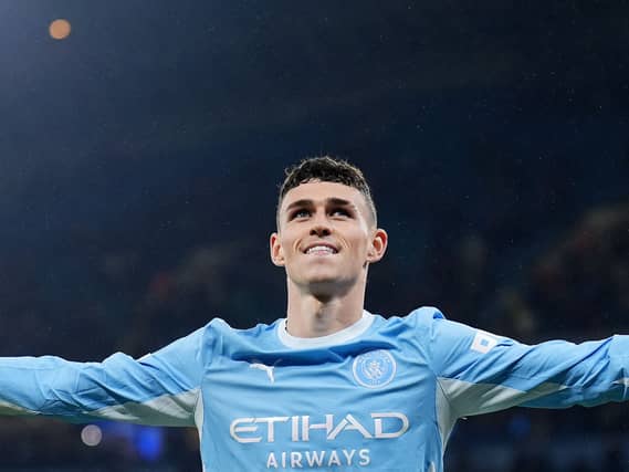 Manchester City’s Phil Foden stretches out his arms as he celebrates scoring against AEK Athens