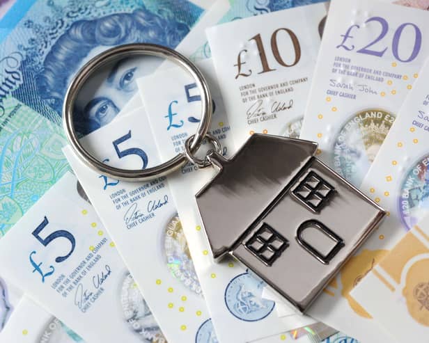 A house keyring on a pile of cash notes