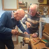 George Cunningham tries out his newfound carpentry skills under the watchful eye of tutor Tom Roche