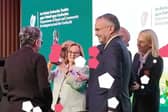 Mary White raises the trophy watched by chair Robbie Quinn, as Abbeyleix Tidy Town wins 2026 Ireland's Tidiest Small Town Award.