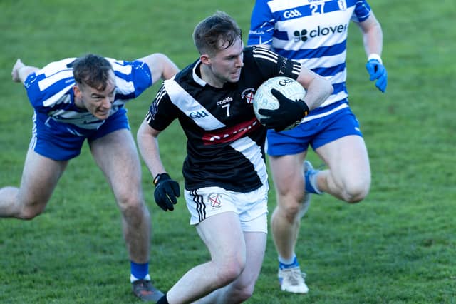 Maynooth wing-back Callum McCabe makes a break up field despite the chasing Naas duo Paddy McDermott and Ciaran Doyle