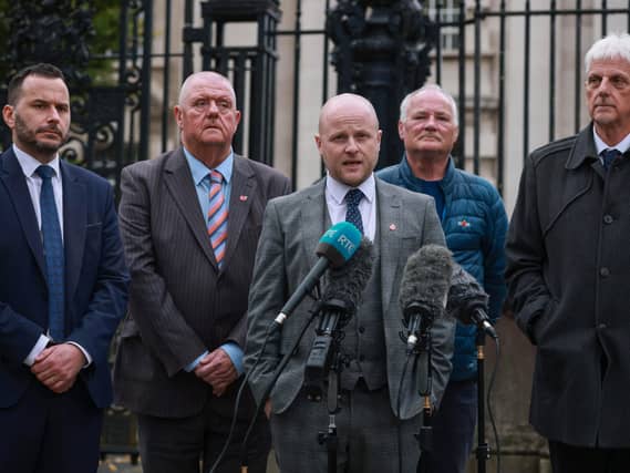 Loyalist spokesperson Jamie Bryson speaking to the media, with Timothy Gaston MLA (left), outside Belfast High Court