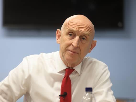 John Healey wearing a white shirt and red tie
