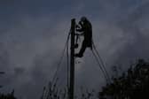 A network technician on a power pole
