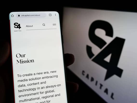 Person holding phone with S4 Capital website on the screen