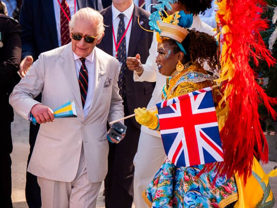 Charles with a performer during the celebratory Junkanoo street parade during a visit to Parliament Square, Nassau