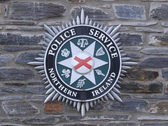 A PSNI badge on a wall outside a station