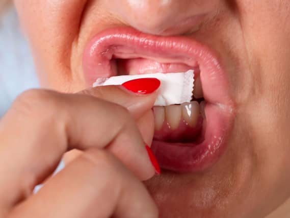 A woman using a nicotine pouch under her lip