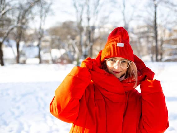 Woman wearing red ski jacket and hat in the snow