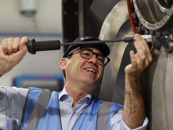 Andy Burnham handling a big screwdriver