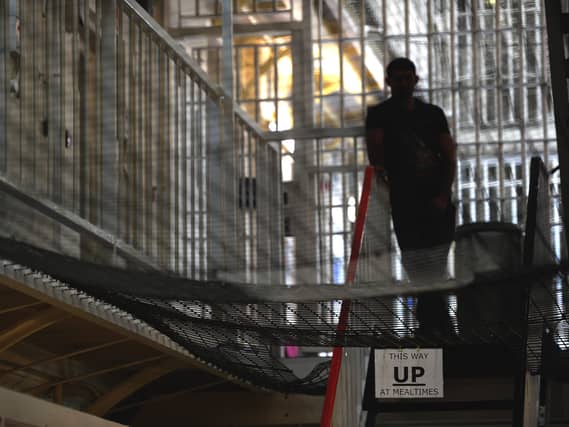 A prisoner standing in a prison wing