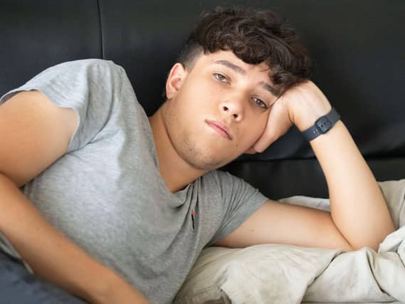 Portrait of a young man lying on a sofa
