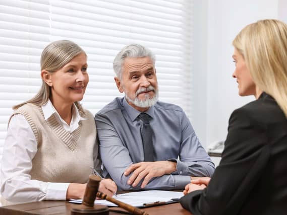 Senior couple talking to a female layer