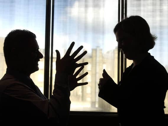 Two people communicate using British Sign Language