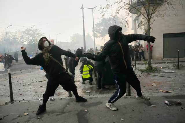Protesters throw stones in Paris (Teresa Suarez/AP)