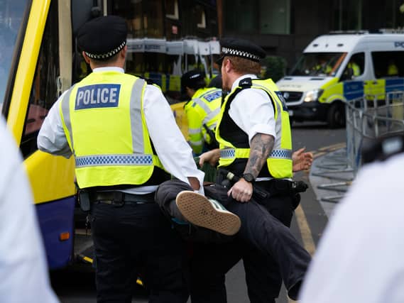 Police carry a person onto a bus